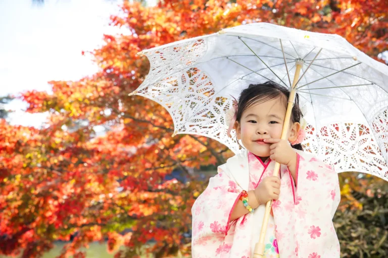 紅葉の中で和傘を持つお子さまの七五三撮影